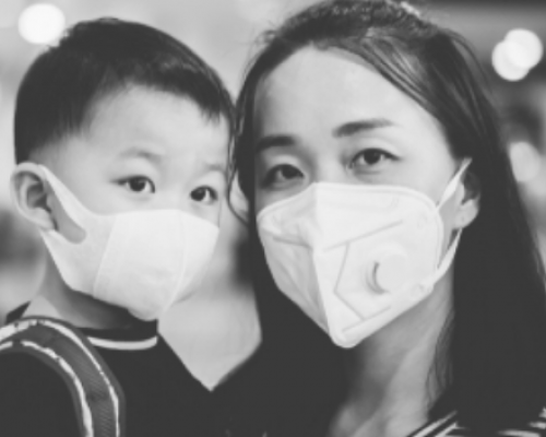 A woman with a child wearing protective masks over their mouths