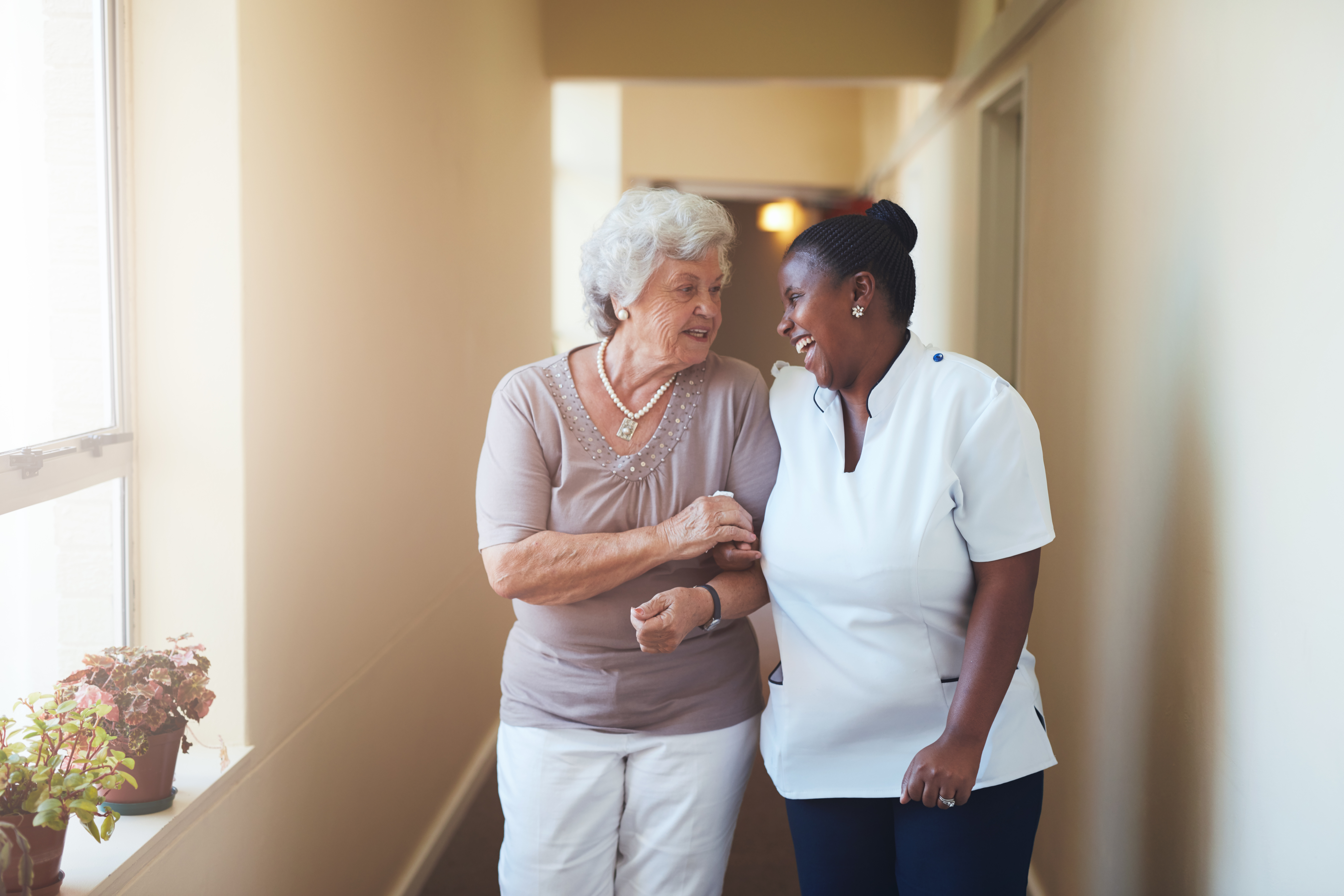 A nurse with a senior woman laughing together