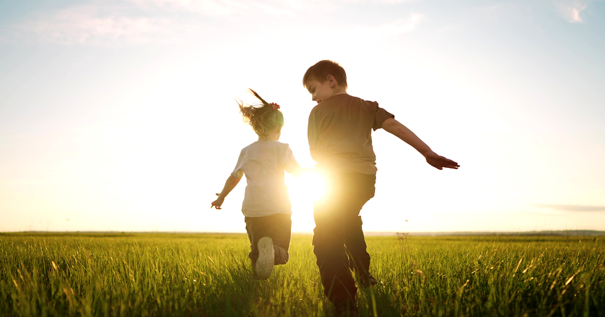 Image of two children running in a field