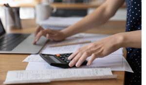 A person using a computer and a calculator