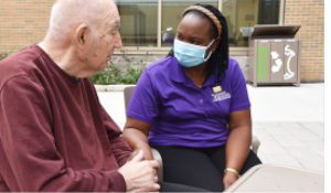 A nurse with a senior touching hands