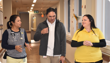 3 nursing taking as they walk down a hospital walkway
