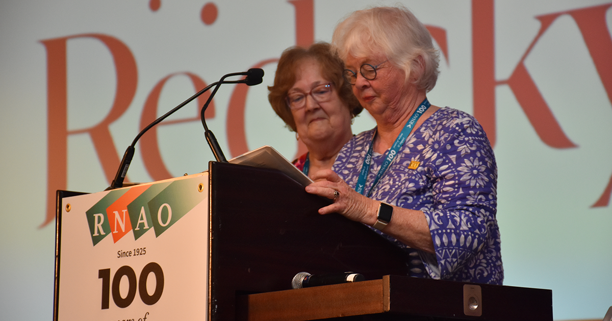 Hosts Una Ferguson (left) and Brenda Hutton of the Staff Nurse Interest Group welcome attendees to RNAO’s 100th Annual General Meeting on May 29. 