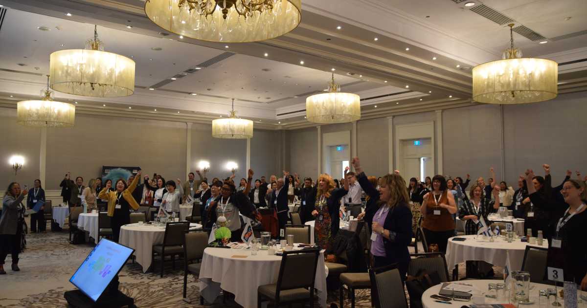 With strong energy in the room, participants perform the BPSO cheer on the first day of orientation.