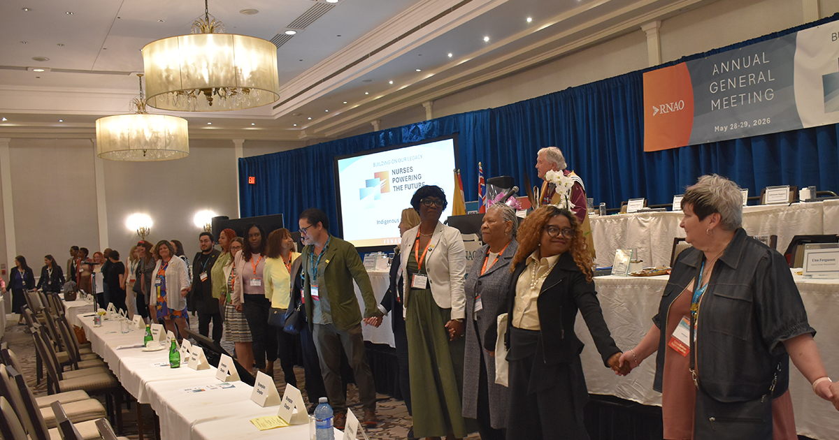 Wide angle shot of multiple AGM participants holding hands to form a ceremonial circle as part of the AGM closing ceremonies on May 28, 2026, overseen by RNAO public representative and Knowledge Keeper Dr. Tecumseh (Ed) Connors.  