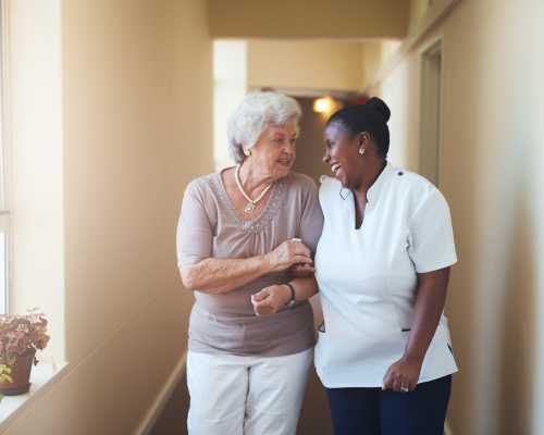 A nurse with a senior woman laughing together
