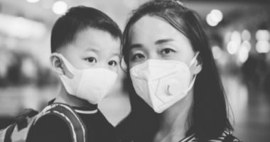 A woman with a child wearing protective masks over their mouths