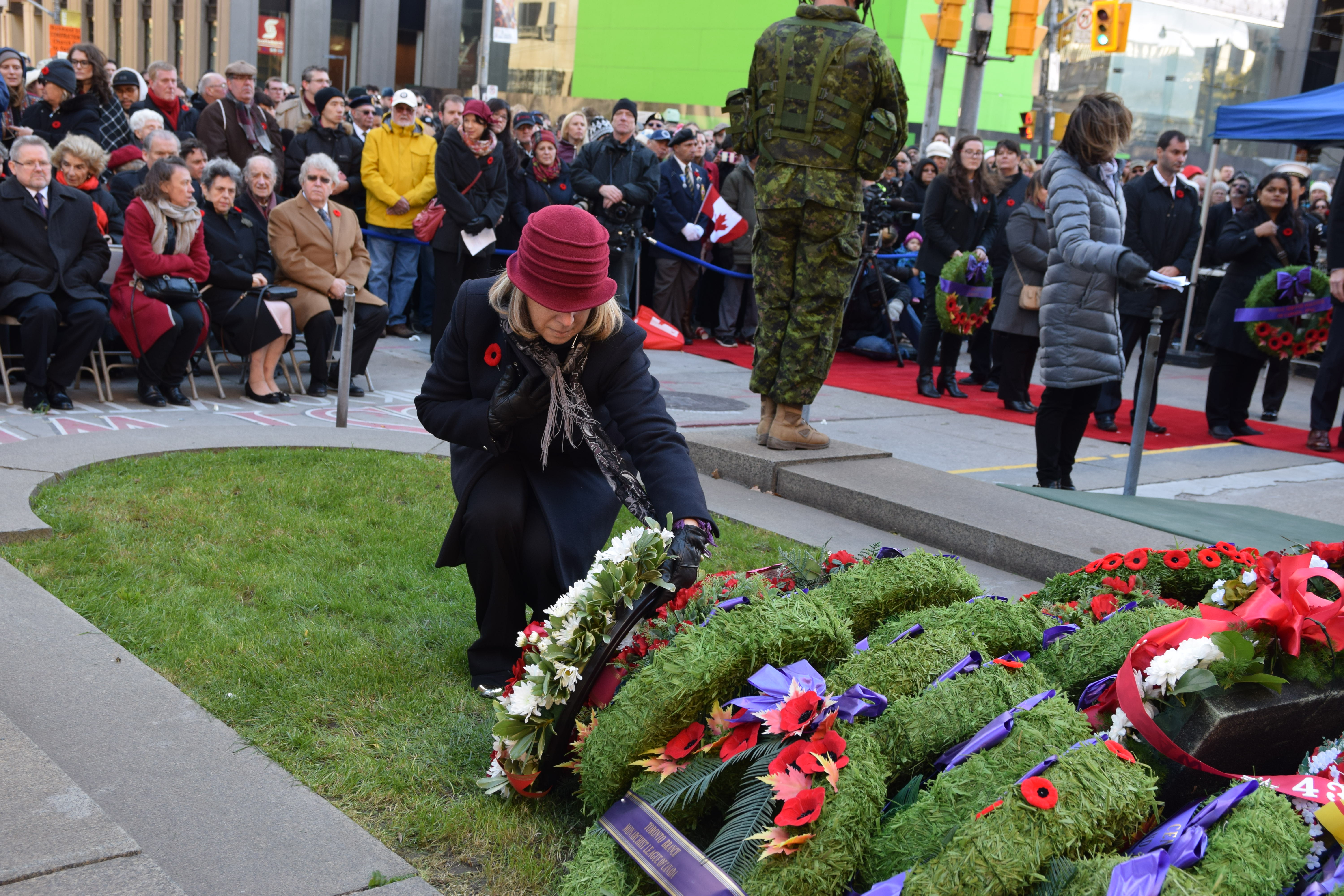 Rhonda Seidman-Carlson is wearing the brown/burgundy hat and placing the wreath
